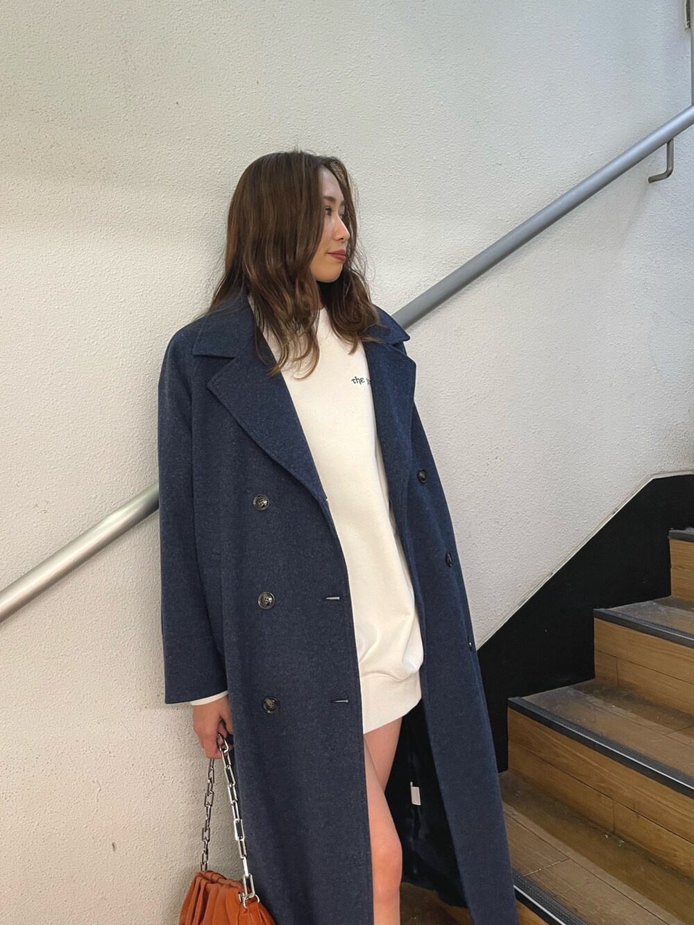 ブラック系のブーツ、ホワイト系のスウェット、ブルー系のその他アウターを着用したレディースの冬コーディネートの3枚目の写真