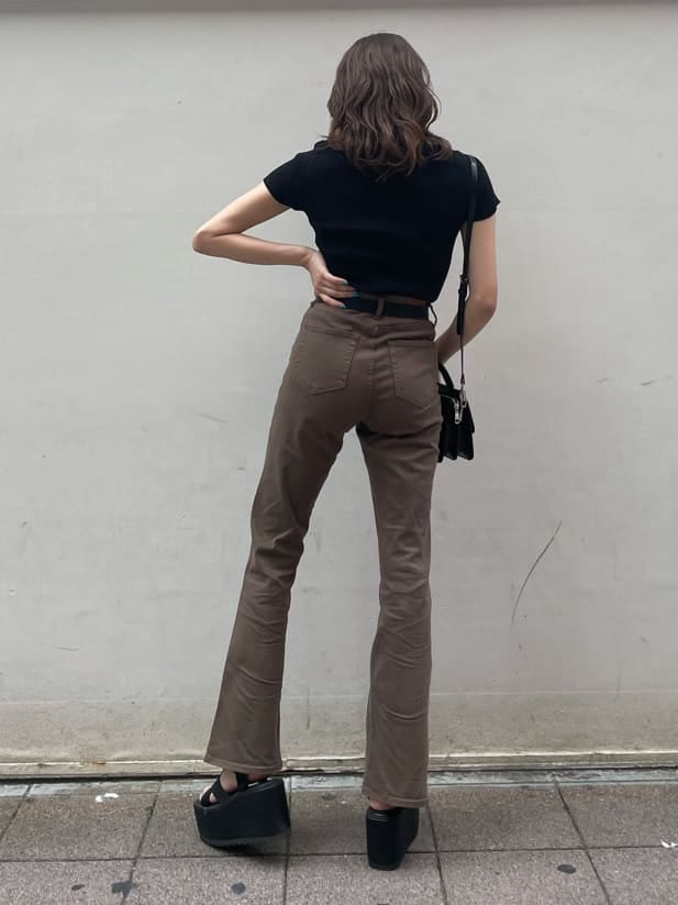 ブラウン系のデニムパンツ、ブラック系のサンダル、ブラック系のニット/セーターを着用したレディースの秋コーディネートの2枚目の写真