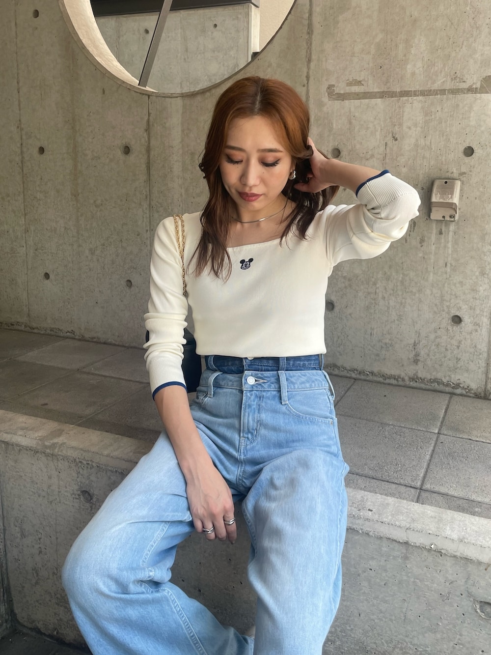 ホワイト系のニット/セーター、ブルー系のデニムパンツ、ブラック系のショルダーバッグを着用したレディースの夏コーディネートの6枚目の写真