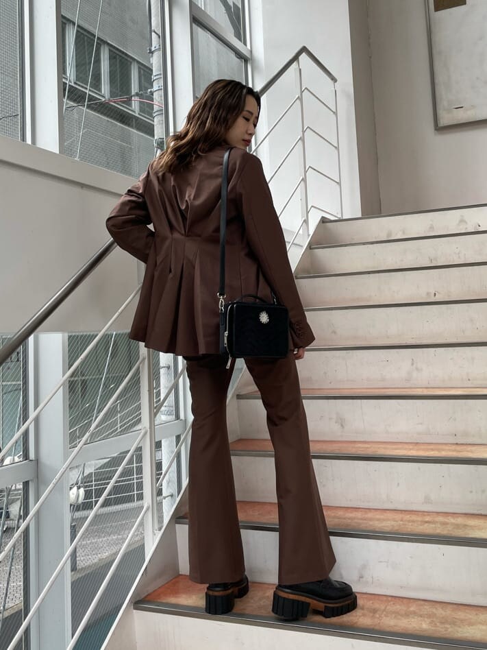 ブラック系のローファー、ブラック系のハンドバッグ、ホワイト系のTシャツ/カットソーを着用したレディースの夏コーディネートの2枚目の写真