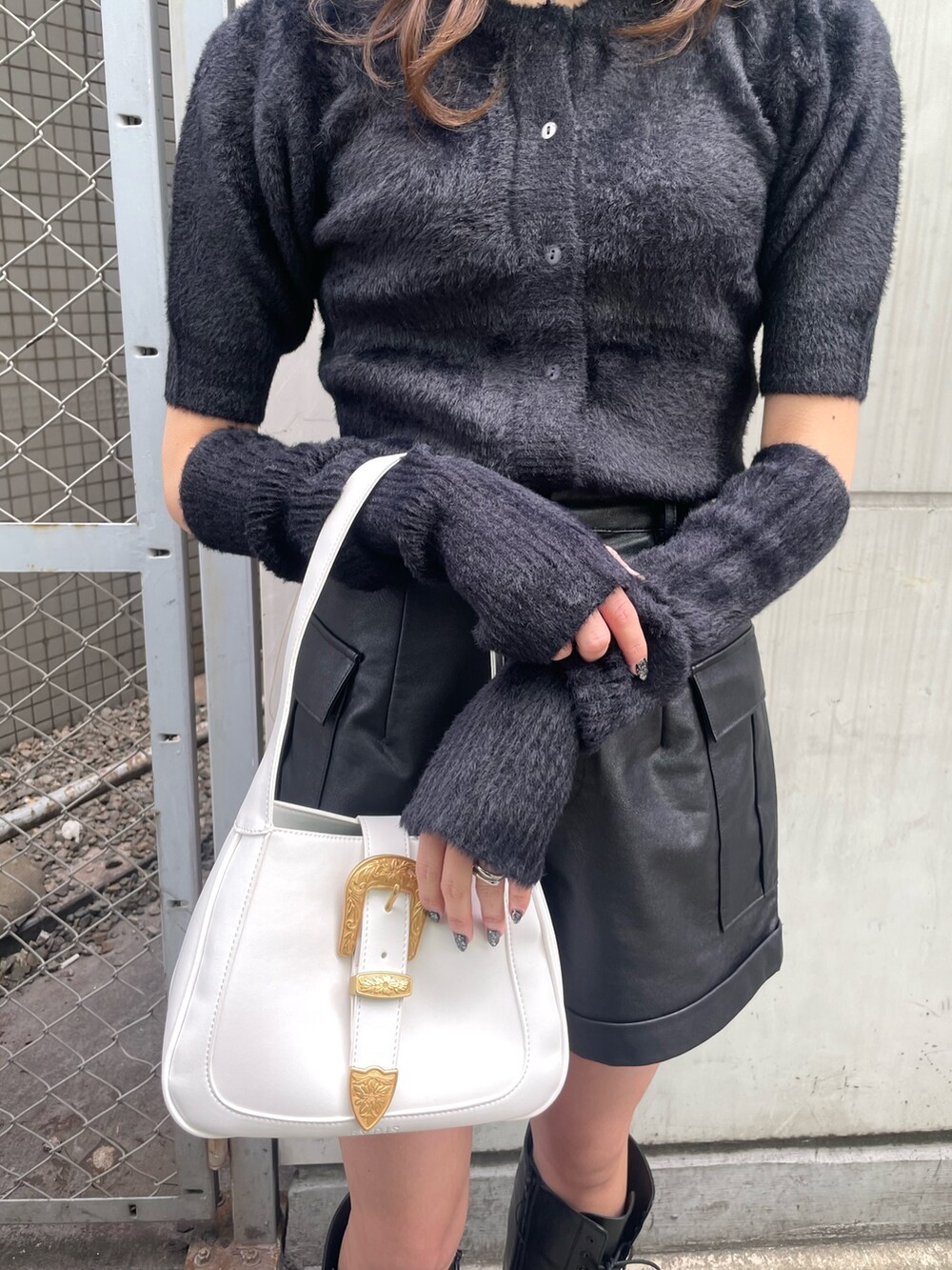 ブラック系のニット/セーター、ブラック系のその他パンツ、ホワイト系のハンドバッグを着用したレディースの冬コーディネートの6枚目の写真