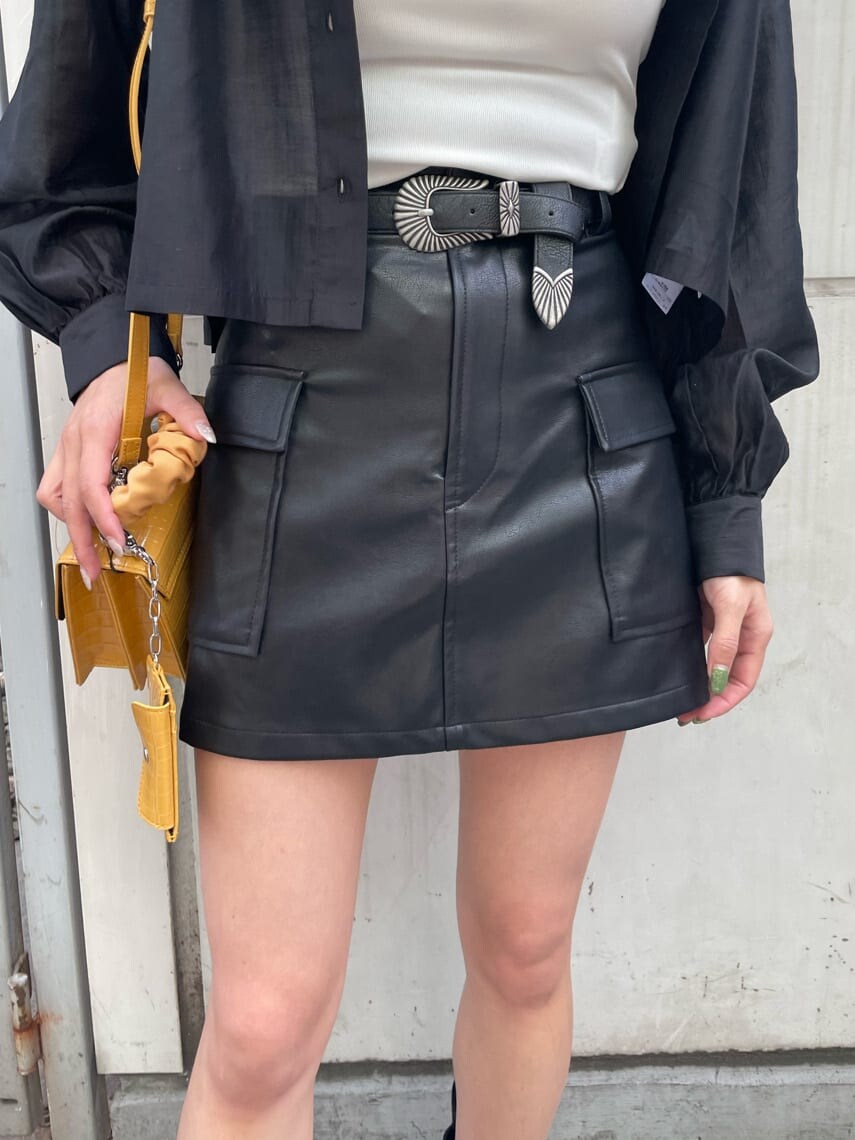 ホワイト系のキャミソール、ブラック系のブーツ、ブラック系のスカートを着用したレディースの春コーディネートの6枚目の写真