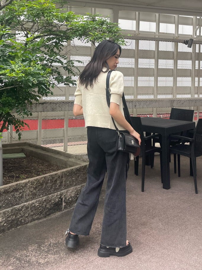 ブラック系のデニムパンツ、ブラック系のキャミソール、ホワイト系のカーディガン/ボレロを着用したレディースの春コーディネートの2枚目の写真