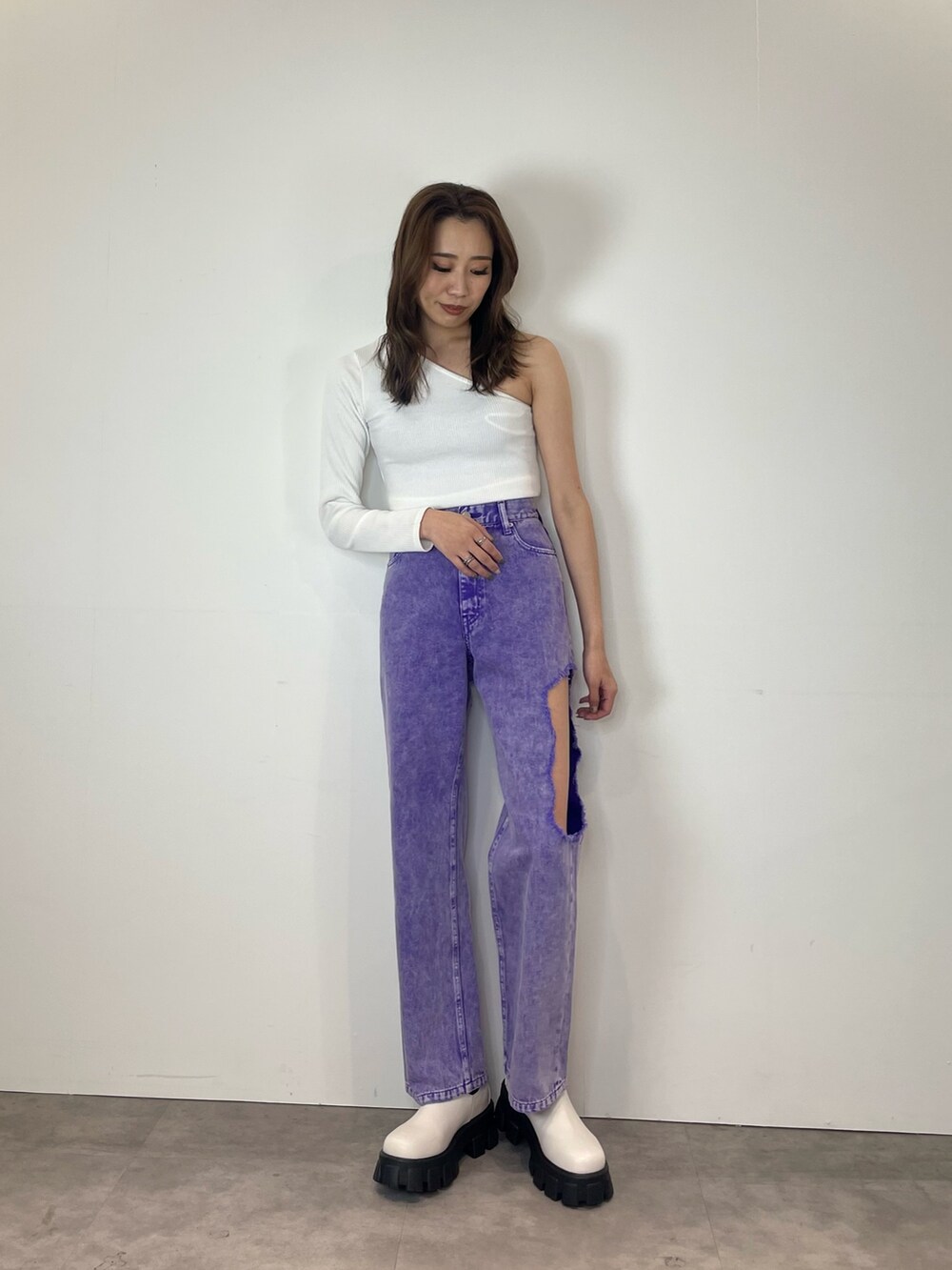 パープル系のデニムパンツ、ホワイト系のブーツを着用したレディースの春コーディネートの5枚目の写真