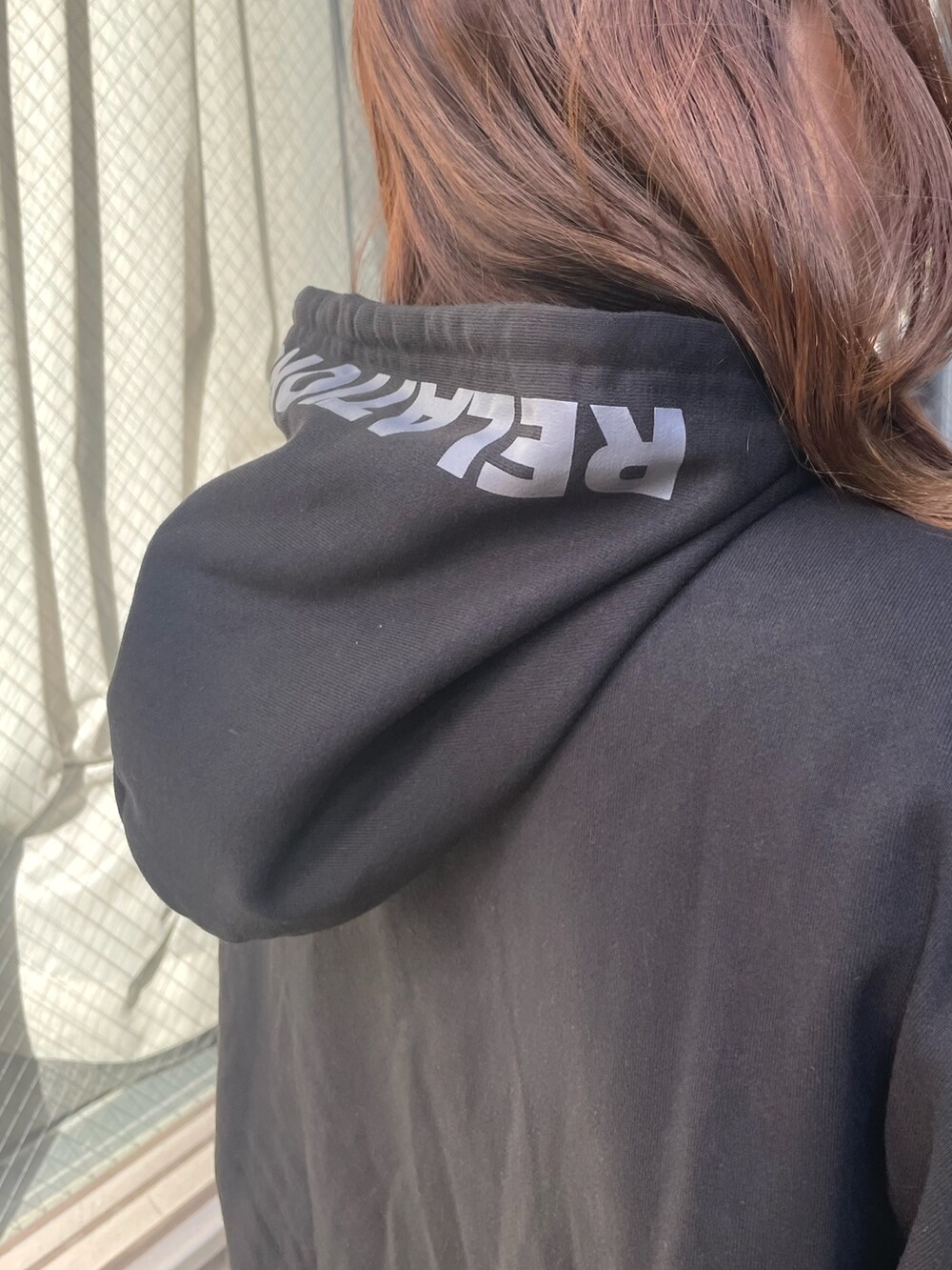 ブラック系のパーカー、ブラック系のショルダーバッグ、ブラック系のワンピースを着用したレディースの冬コーディネートの6枚目の写真