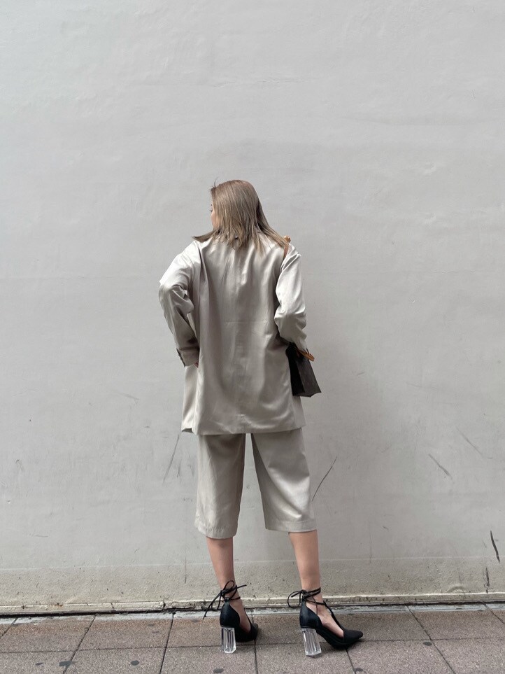 グレー系のテーラードジャケット、ブラック系のパンプス、ブラック系のタンクトップを着用したレディースの春コーディネートの7枚目の写真