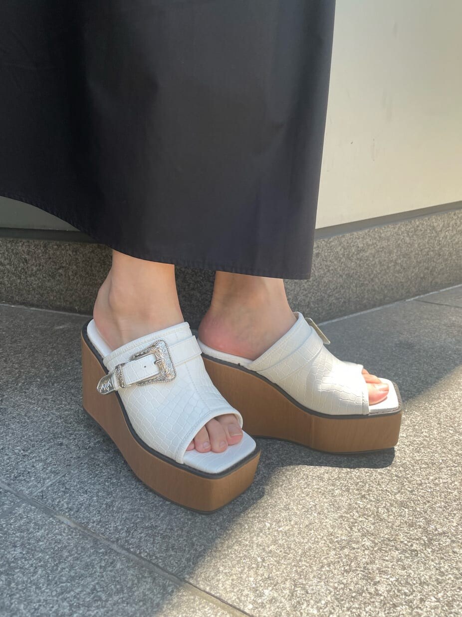 ブラック系のワンピース、ホワイト系のサンダル、ホワイト系のショルダーバッグを着用したレディースの春コーディネートの7枚目の写真