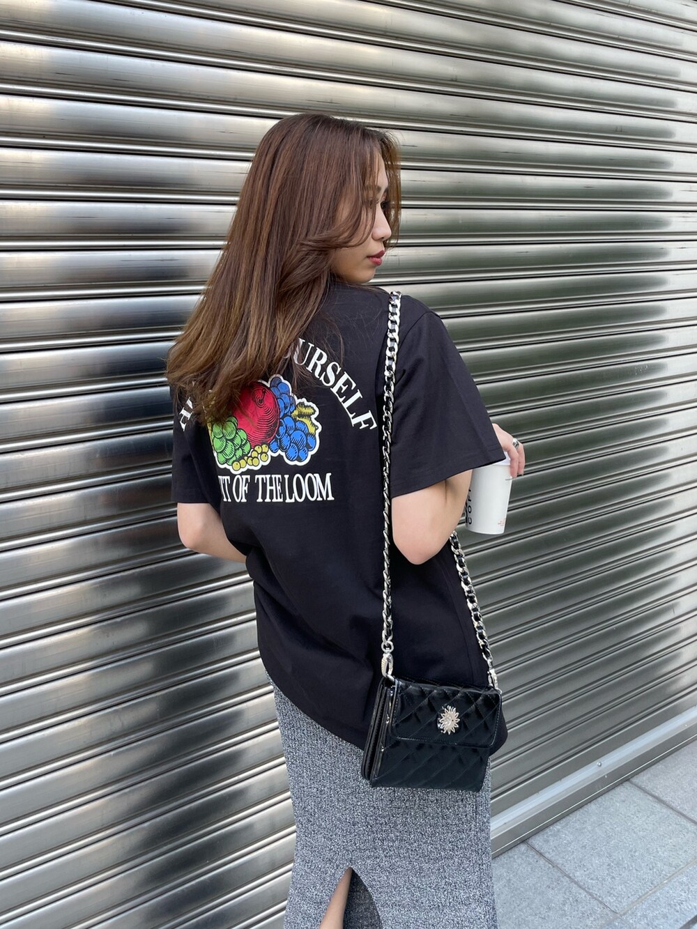 ブラック系のTシャツ/カットソー、ブラック系のショルダーバッグ、ブラック系のブーツを着用したレディースの春コーディネートの4枚目の写真