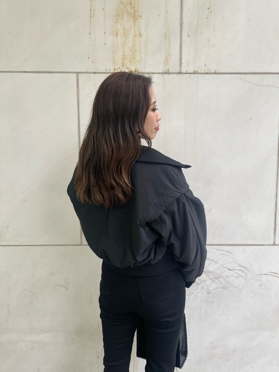 ブラック系のブーツ、ブラック系のデニムパンツ、ブラック系のショルダーバッグを着用したレディースの秋コーディネートの5枚目の写真