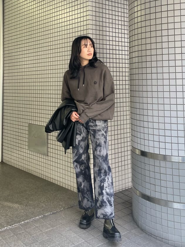 ブラック系のテーラードジャケット、ベージュ系のブーツ、ブラック系のデニムパンツを着用したレディースの春コーディネートの3枚目の写真