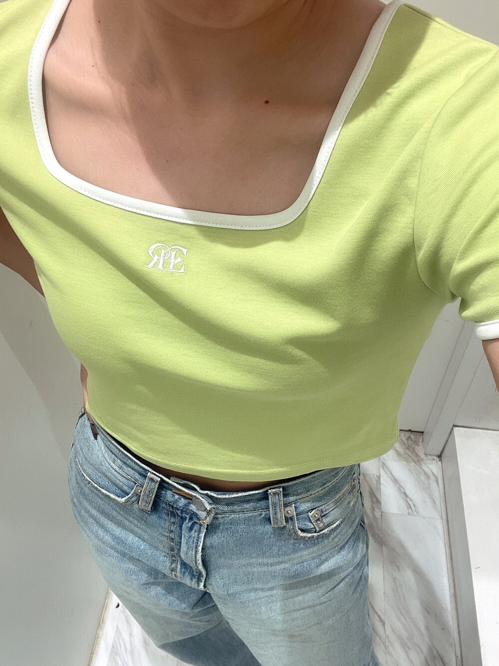 グリーン系のTシャツ/カットソー、ブルー系のデニムパンツを着用したレディースの春コーディネートの3枚目の写真