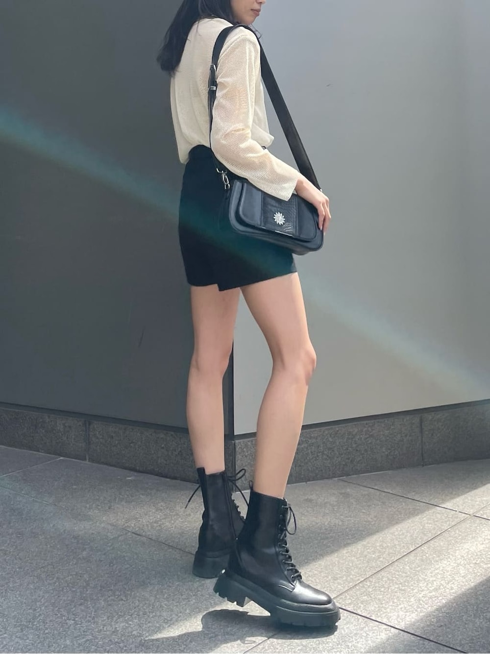 ブラック系のブーツ、ブラック系のその他パンツ、ホワイト系のTシャツ/カットソーを着用したレディースの春コーディネートの3枚目の写真