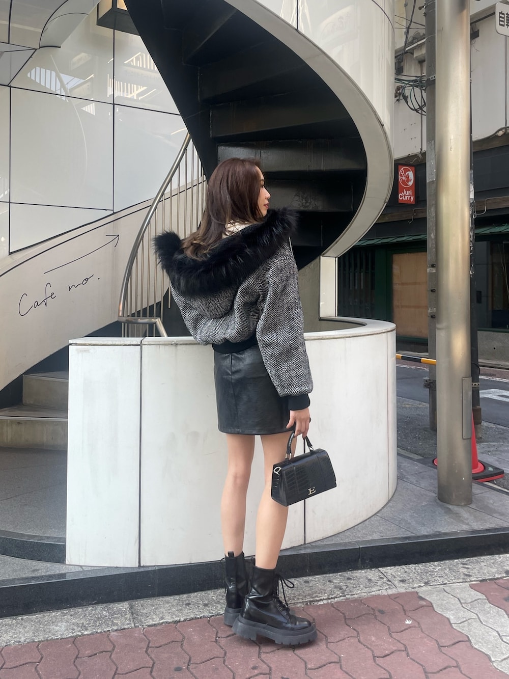 ブラック系のショルダーバッグ、ブラック系のブーツ、ブラック系のスカートを着用したレディースの秋コーディネートの2枚目の写真