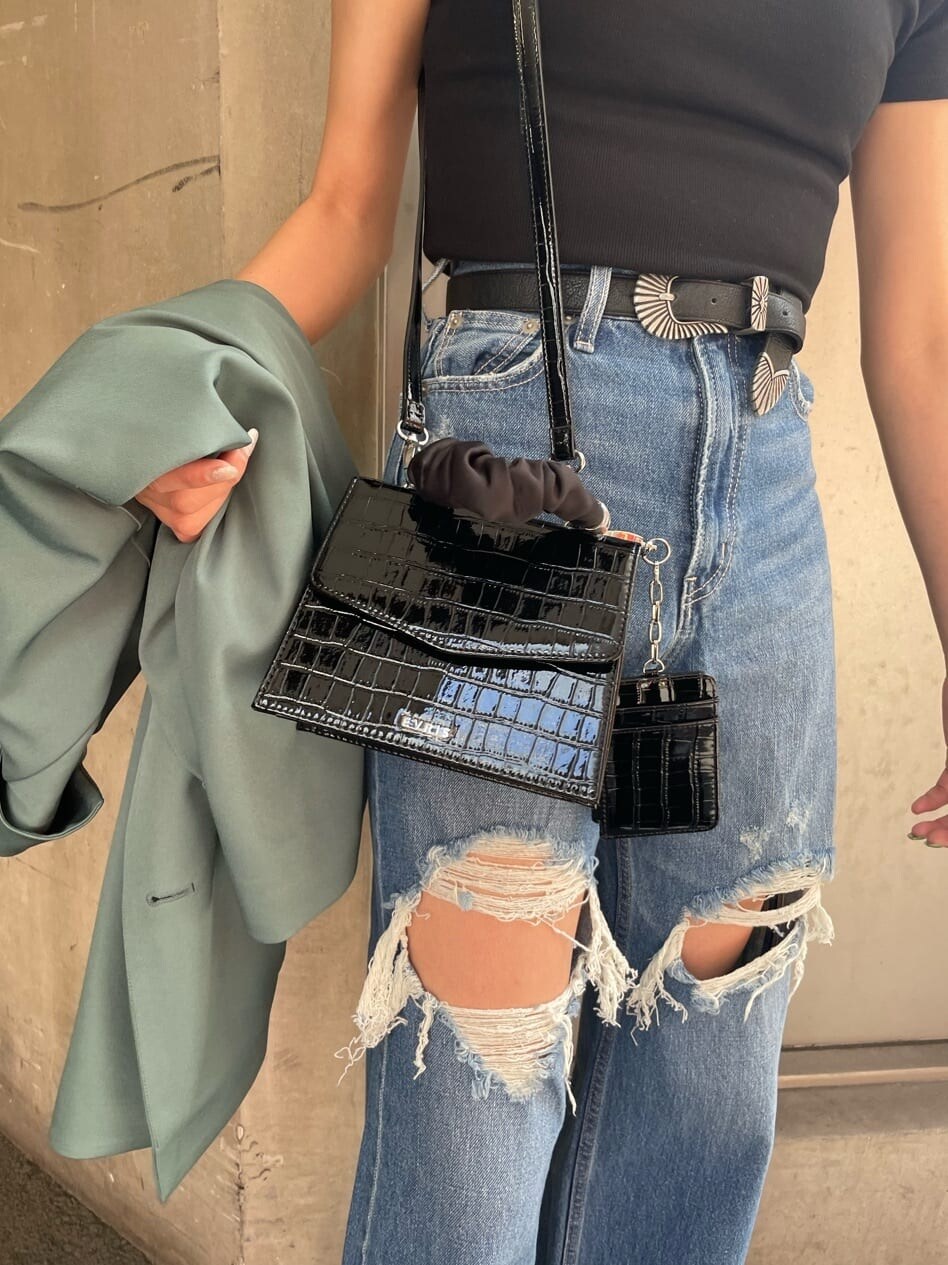 ブラック系のブーツ、ブルー系のデニムパンツ、ブラック系のTシャツ/カットソーを着用したレディースの春コーディネートの8枚目の写真