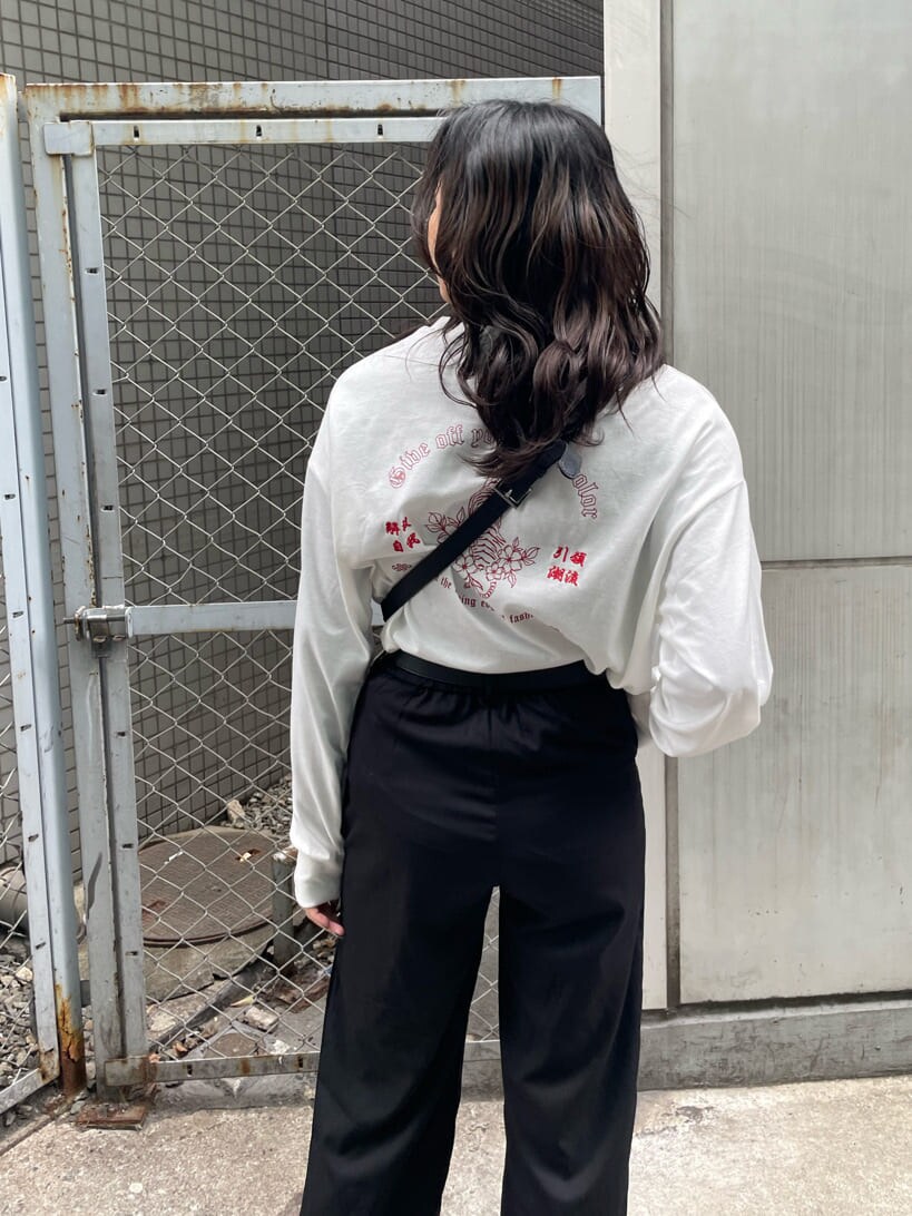 ブラック系のボディバッグ/ウエストポーチ、ブラック系のブーツ、ホワイト系のTシャツ/カットソーを着用したレディースの冬コーディネートの3枚目の写真