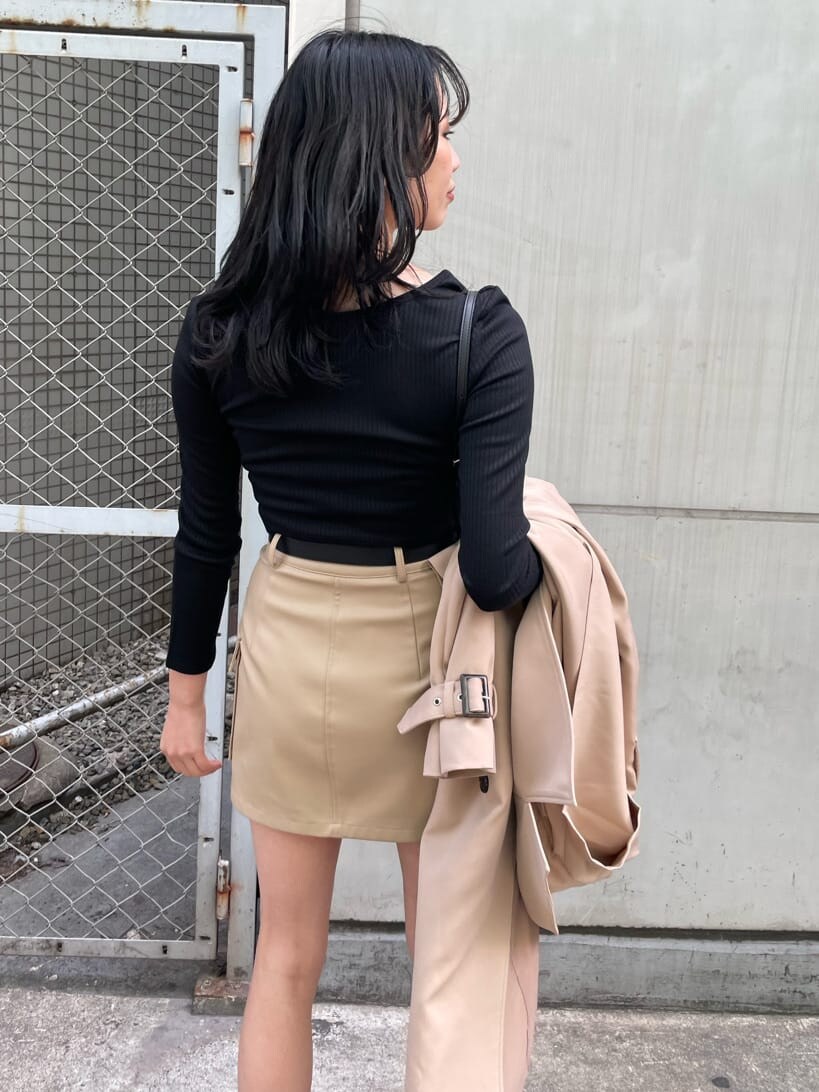 ブラック系のブーツ、ベージュ系のトレンチコート、ブラック系のショルダーバッグを着用したレディースの春コーディネートの6枚目の写真