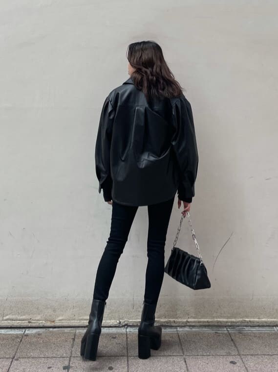 ブラック系のテーラードジャケット、ブラック系のショルダーバッグ、ブラック系のブーツを着用したレディースの冬コーディネートの4枚目の写真