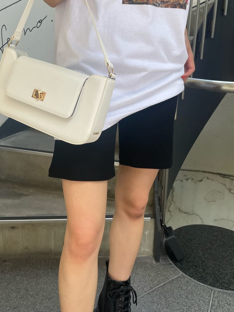 ブラック系のブーツ、ホワイト系のショルダーバッグ、ブラック系のその他パンツを着用したレディースの夏コーディネートの5枚目の写真