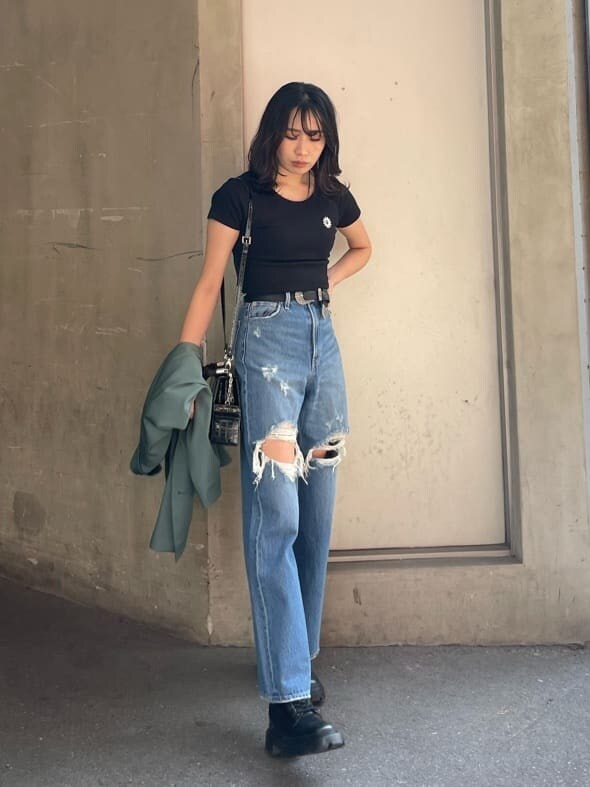 ブラック系のブーツ、ブルー系のデニムパンツ、ブラック系のTシャツ/カットソーを着用したレディースの春コーディネートの2枚目の写真