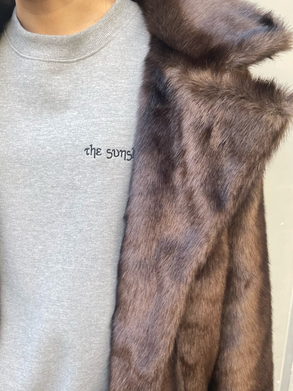 グレー系のスウェット、ブラック系のショルダーバッグ、ブラック系のブーツを着用したレディースの冬コーディネートの7枚目の写真