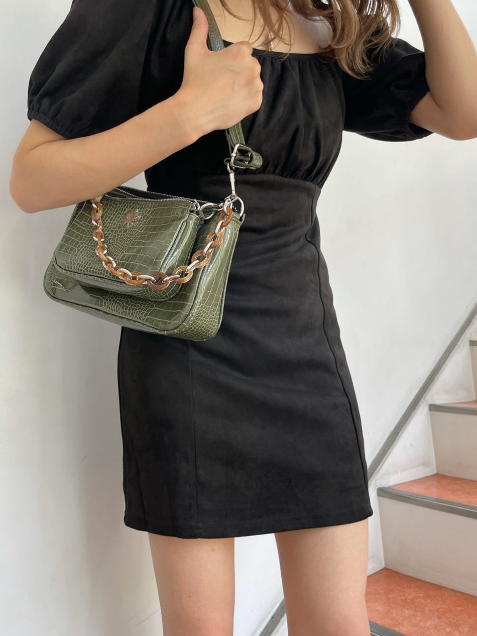 ブラック系のワンピース、ブラック系のブーツ、ベージュ系のショルダーバッグを着用したレディースの秋コーディネートの2枚目の写真