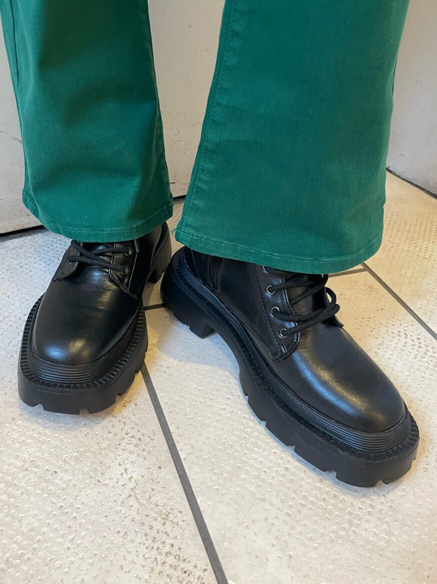 ブラック系のブーツ、ホワイト系のTシャツ/カットソー、グリーン系のデニムパンツを着用したレディースの春コーディネートの8枚目の写真