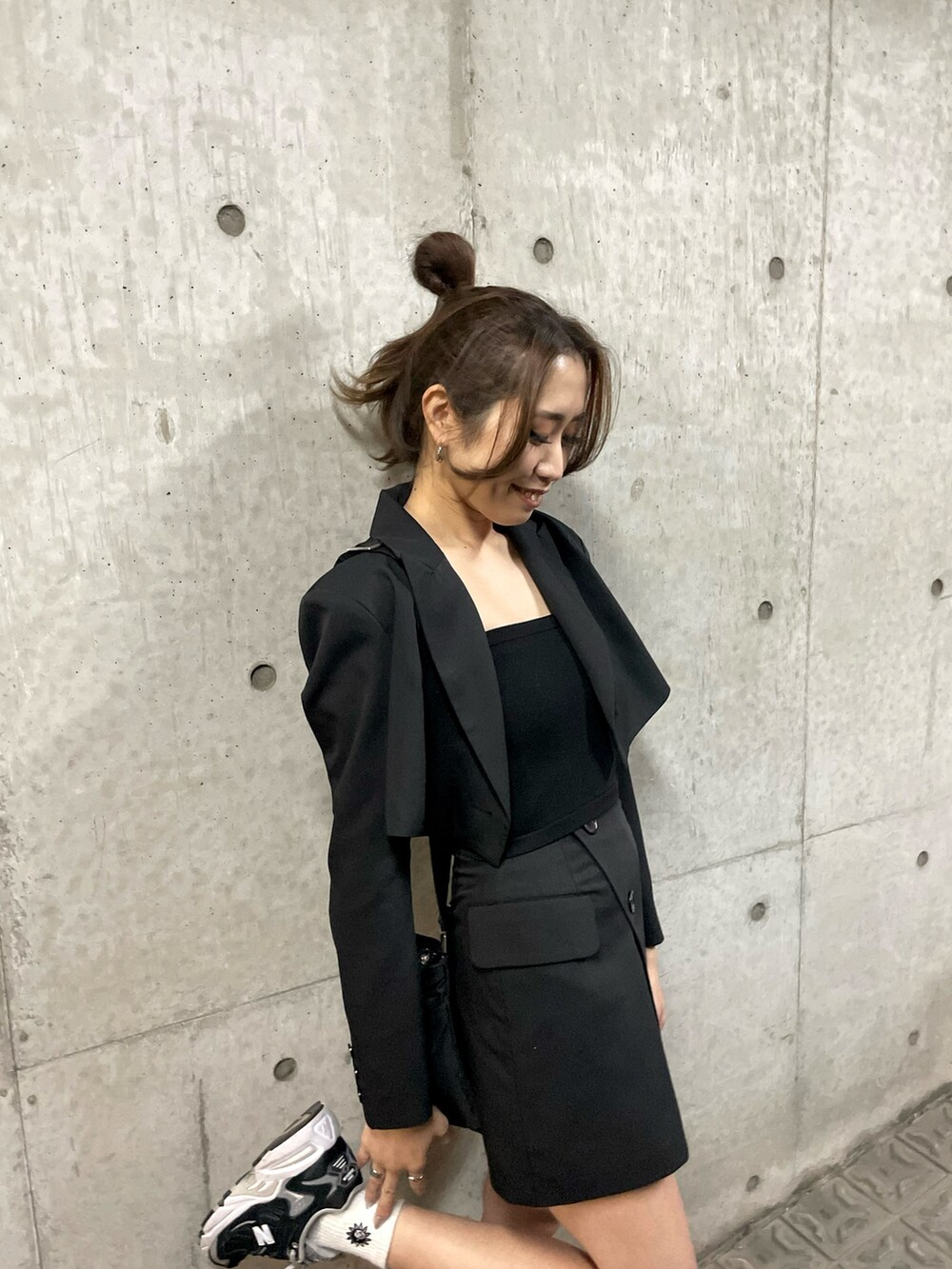 ブラック系のテーラードジャケット、ブラック系のスカート、ブラック系のニット/セーターを着用したレディースの春コーディネートの4枚目の写真