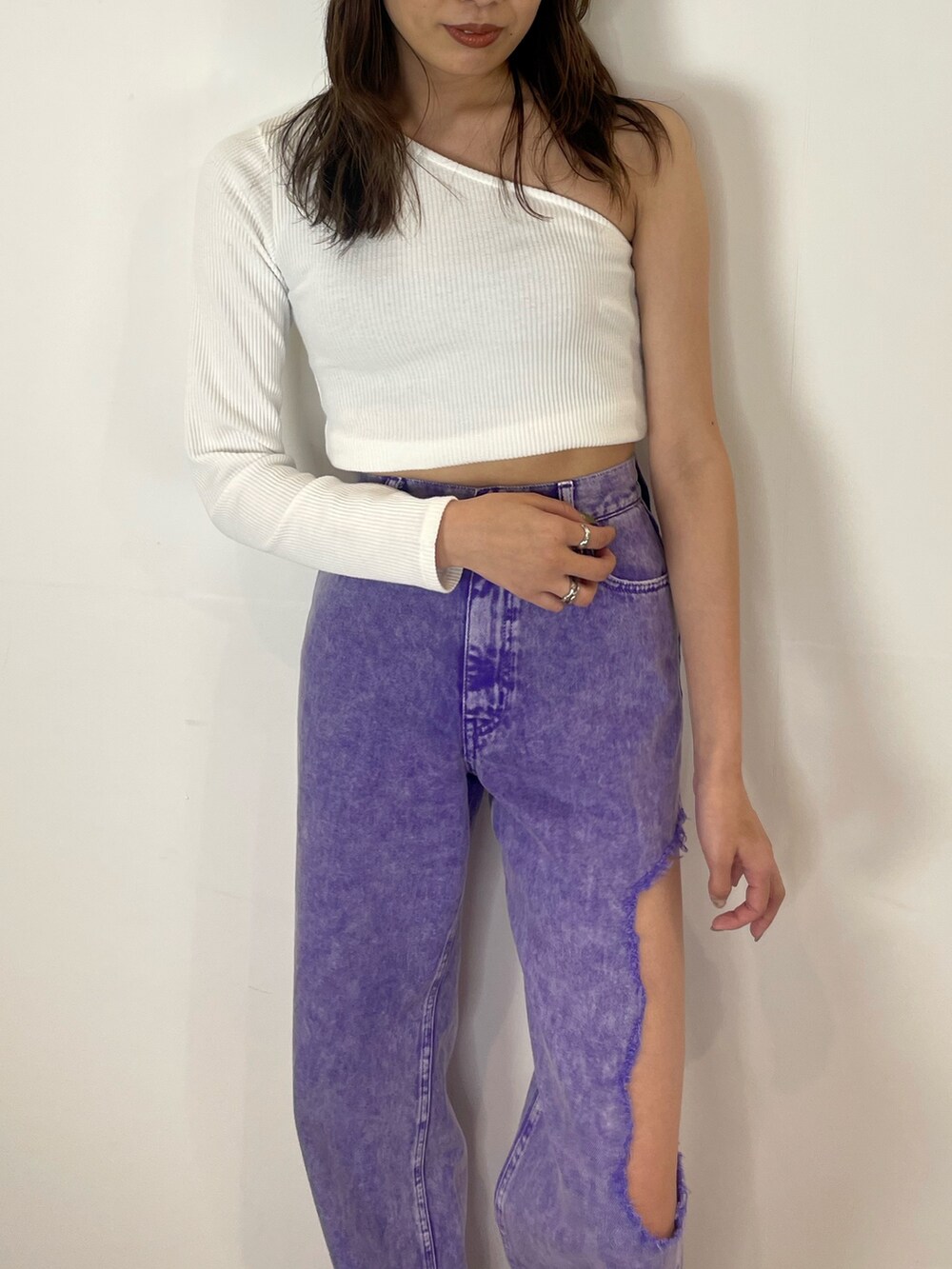 パープル系のデニムパンツ、ホワイト系のブーツを着用したレディースの春コーディネートの3枚目の写真