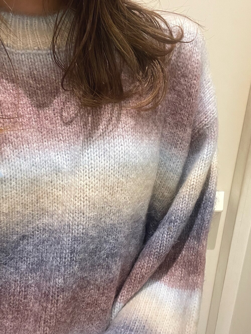 パープル系のニット/セーター、ブラック系のハンドバッグ、ブラック系のブーツを着用したレディースの秋コーディネートの6枚目の写真