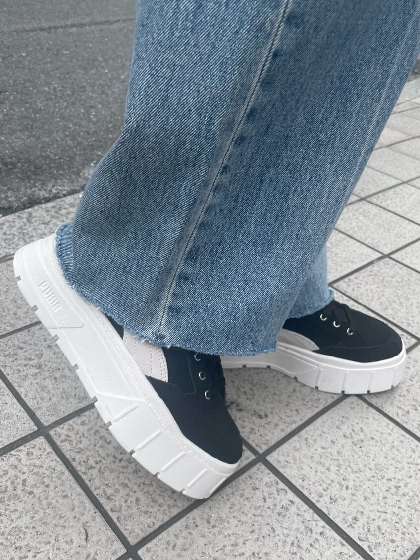 グリーン系のショルダーバッグ、ブルー系のデニムパンツ、ブラック系のスニーカーを着用したレディースの夏コーディネートの9枚目の写真