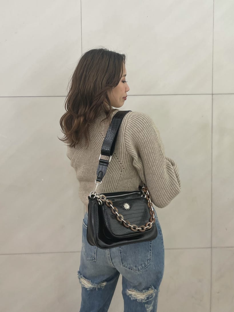 ブルー系のデニムパンツ、ホワイト系のニット/セーター、ブラック系のベルトを着用したレディースの秋コーディネートの4枚目の写真