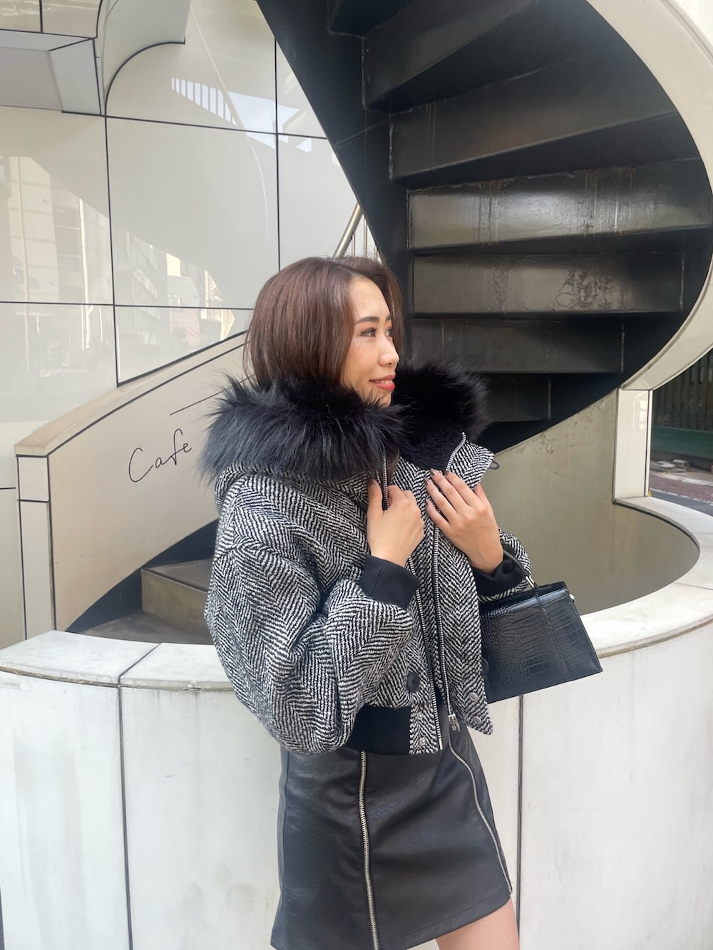 ブラック系のショルダーバッグ、ブラック系のブーツ、ブラック系のスカートを着用したレディースの秋コーディネートの4枚目の写真