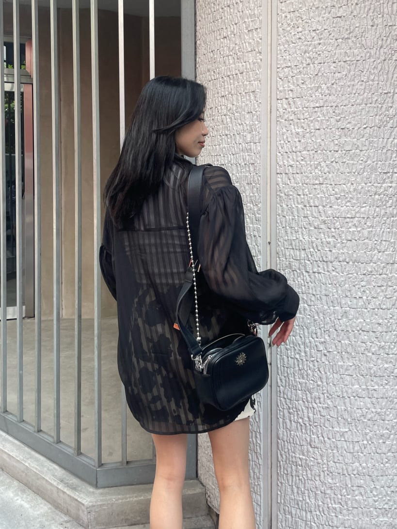 ブラック系のブーツ、ブラック系のシャツ/ブラウス、ブラック系のショルダーバッグを着用したレディースの夏コーディネートの4枚目の写真