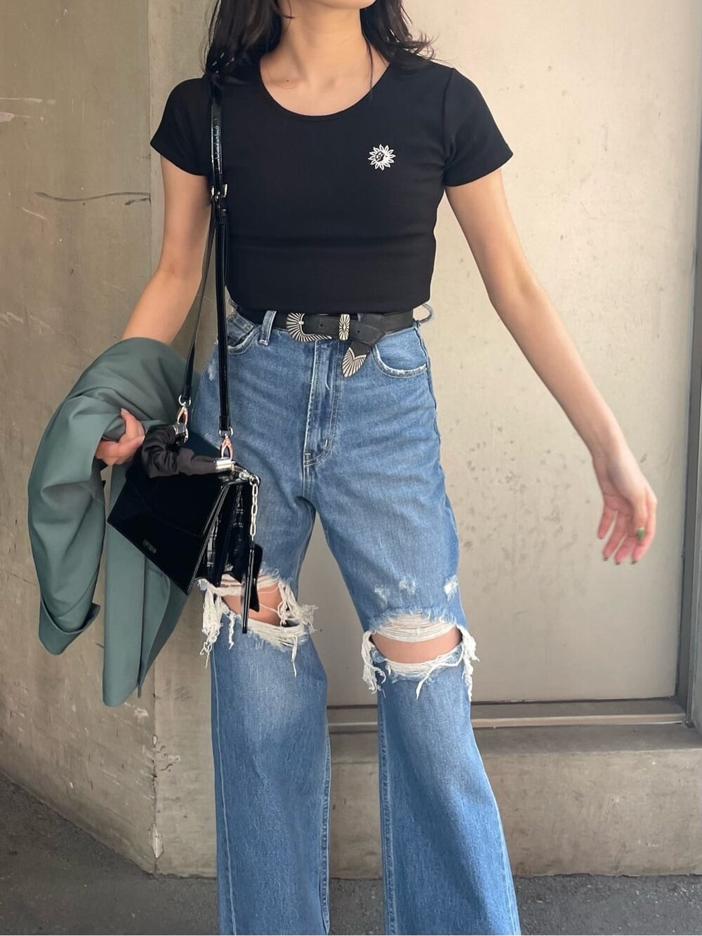 ブラック系のブーツ、ブルー系のデニムパンツ、ブラック系のTシャツ/カットソーを着用したレディースの春コーディネートの4枚目の写真