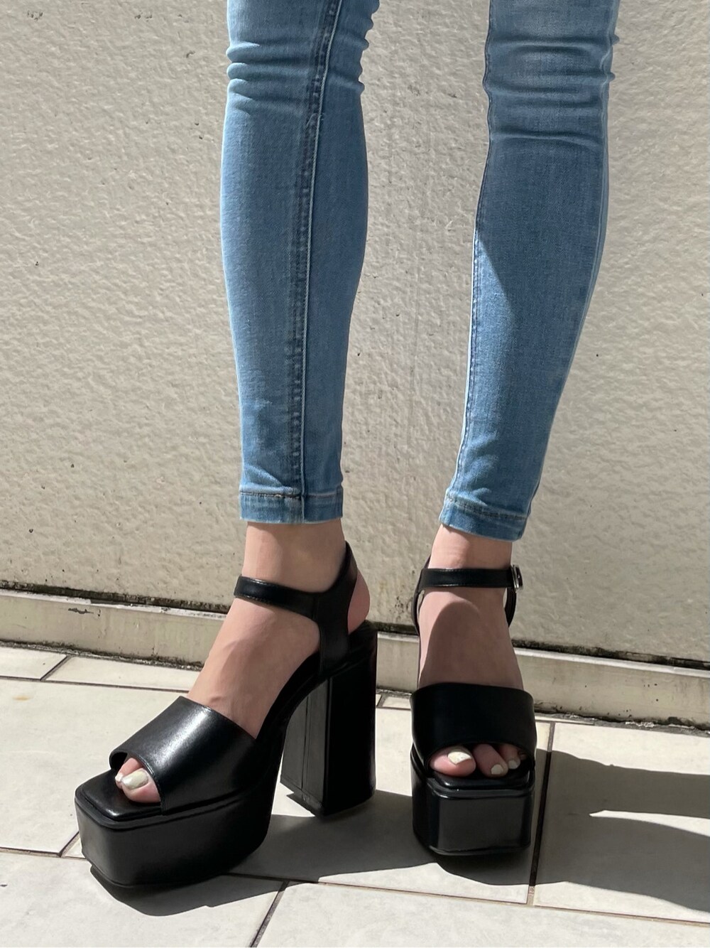 ブラック系のショルダーバッグ、ブルー系のデニムパンツ、ホワイト系のシャツ/ブラウスを着用したレディースの春コーディネートの6枚目の写真