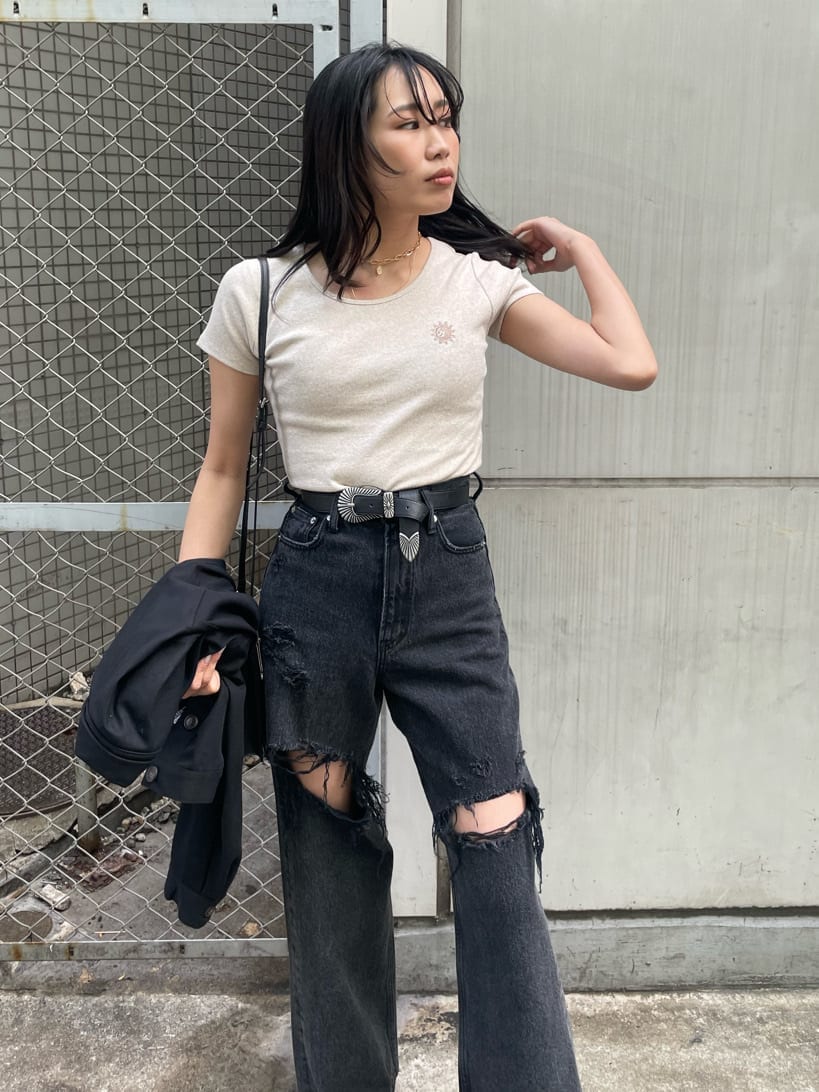 ブラック系のショルダーバッグ、ブラック系のデニムパンツ、ブラック系のブーツを着用したレディースの春コーディネートの4枚目の写真