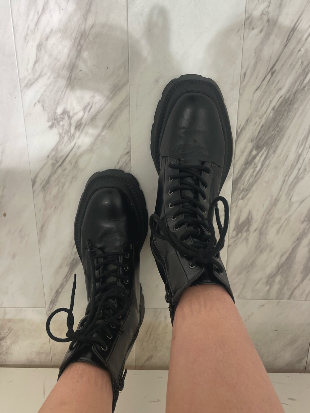 パープル系のニット/セーター、ブラック系のハンドバッグ、ブラック系のブーツを着用したレディースの秋コーディネートの7枚目の写真