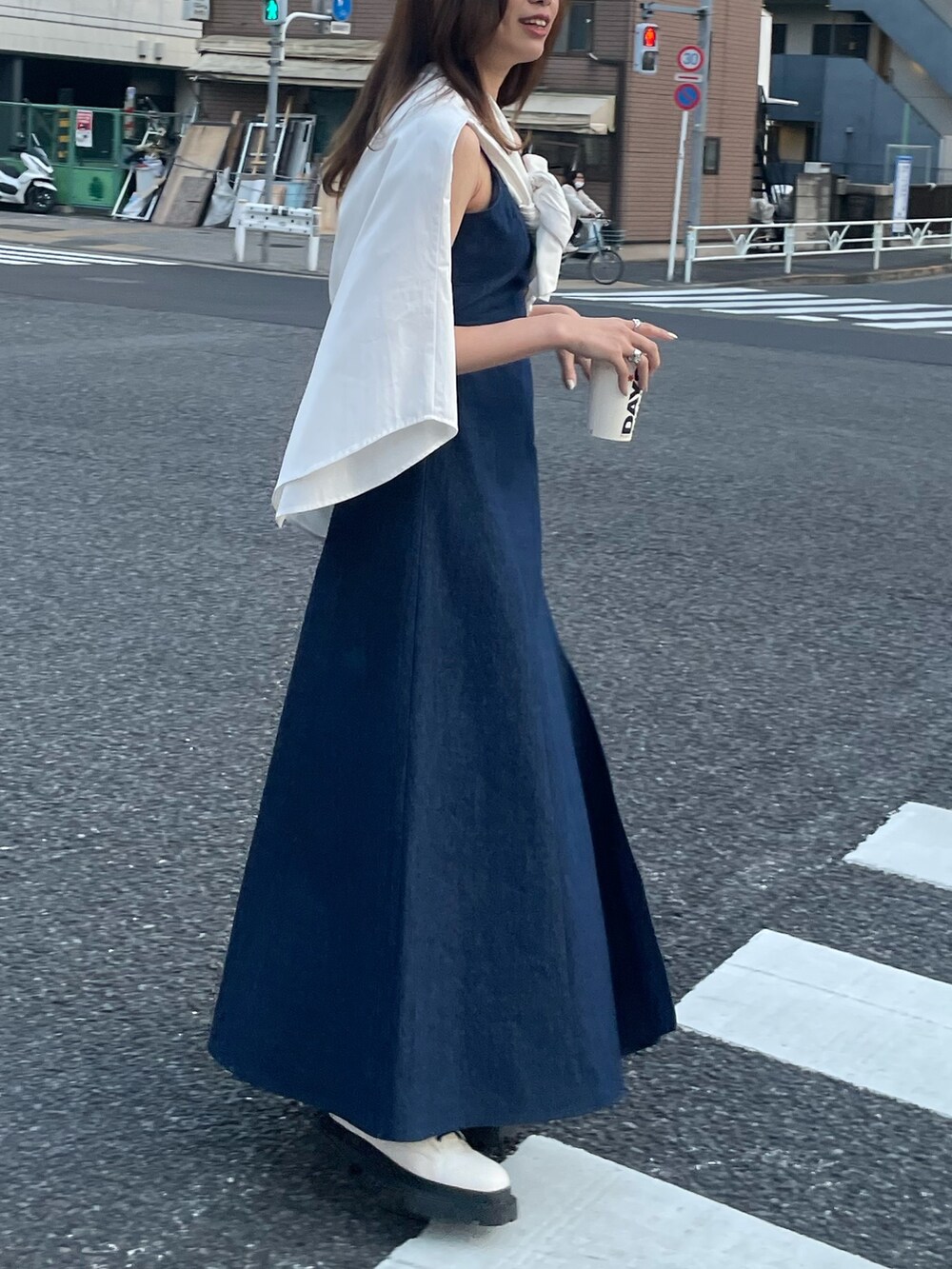 ホワイト系のシャツ/ブラウス、ブルー系のワンピース、ホワイト系のブーツを着用したレディースの春コーディネートの4枚目の写真