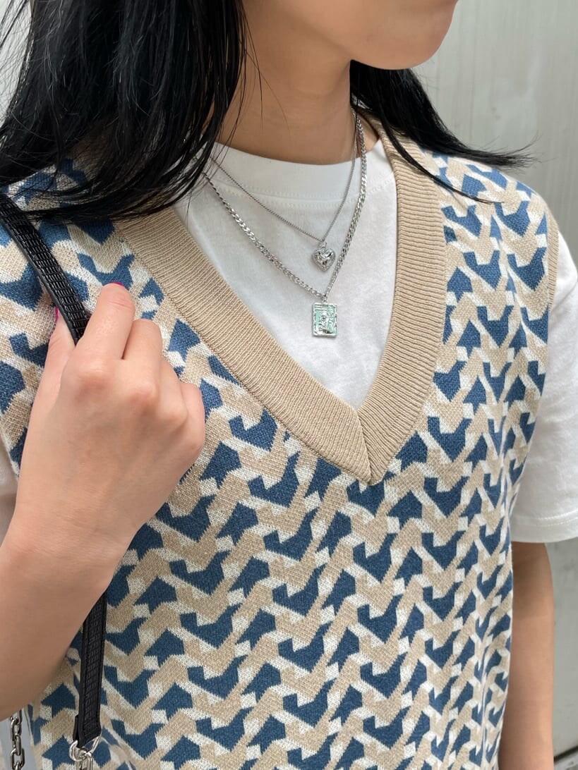 ブラック系のブーツ、ベージュ系のニット/セーター、ホワイト系のTシャツ/カットソーを着用したレディースの春コーディネートの6枚目の写真