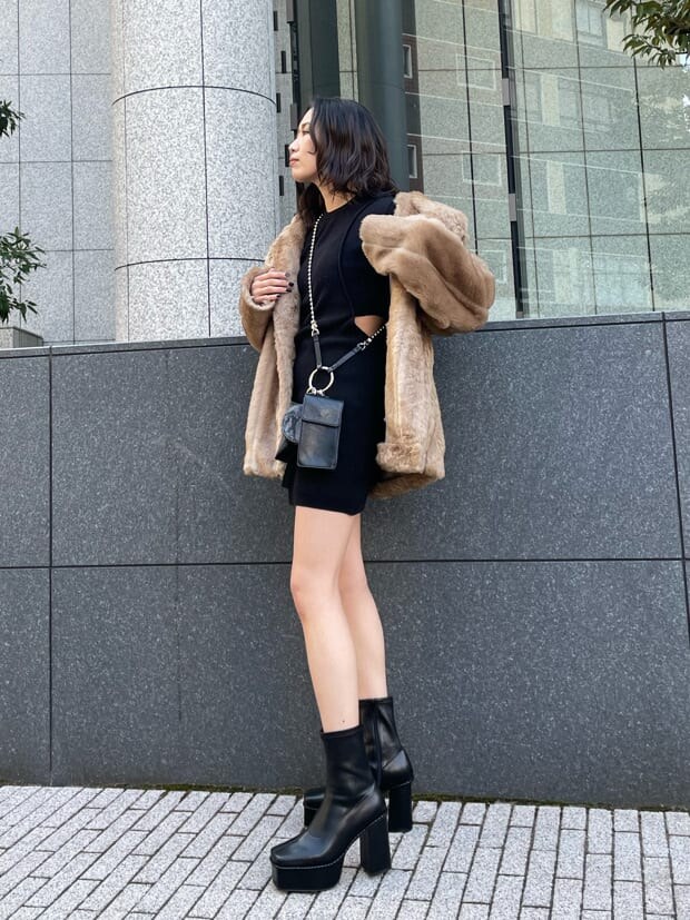 ベージュ系のその他アウター、ブラック系のハンドバッグ、ブラック系のブーツを着用したレディースの冬コーディネートの2枚目の写真