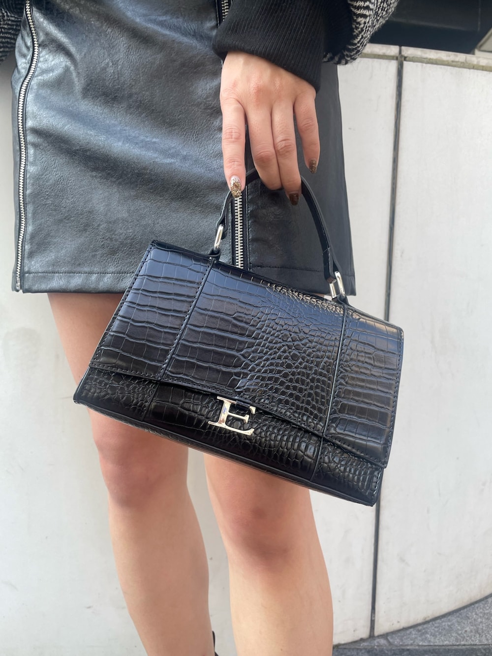 ブラック系のショルダーバッグ、ブラック系のブーツ、ブラック系のスカートを着用したレディースの秋コーディネートの7枚目の写真