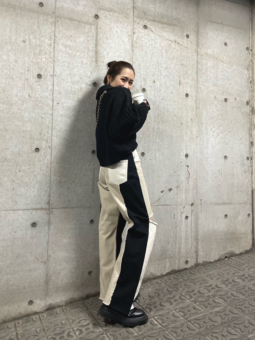 ブラック系のブーツ、ホワイト系のショルダーバッグ、ブラック系のニット/セーターを着用したレディースの冬コーディネートの3枚目の写真