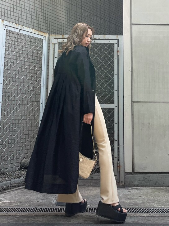 ホワイト系のショルダーバッグ、ブラック系のその他アウター、ブラック系のサンダルを着用したレディースの春コーディネートの2枚目の写真