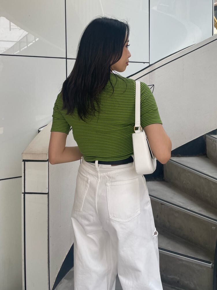 グリーン系のTシャツ/カットソー、ホワイト系のショルダーバッグ、ホワイト系のデニムパンツを着用したレディースの春コーディネートの5枚目の写真