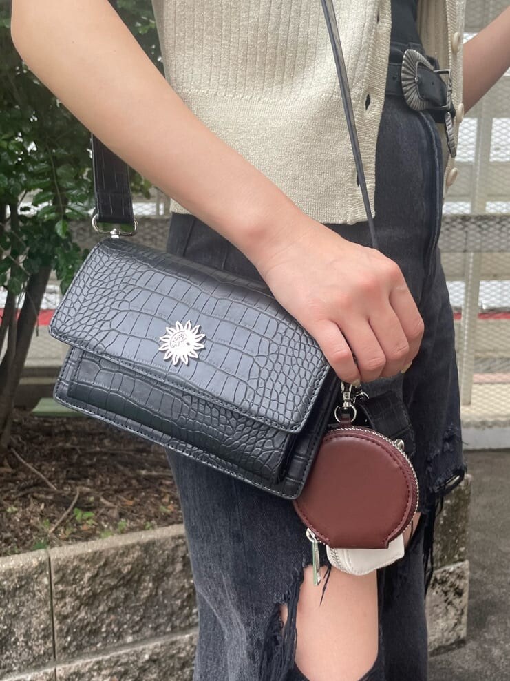 ブラック系のデニムパンツ、ブラック系のキャミソール、ホワイト系のカーディガン/ボレロを着用したレディースの春コーディネートの5枚目の写真