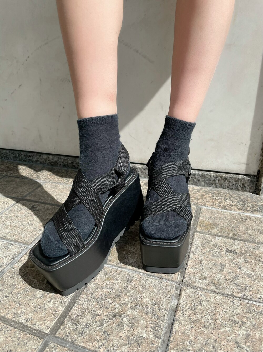 ブラウン系のスカート、ブラック系のショルダーバッグ、ブラック系のテーラードジャケットを着用したレディースの春コーディネートの6枚目の写真