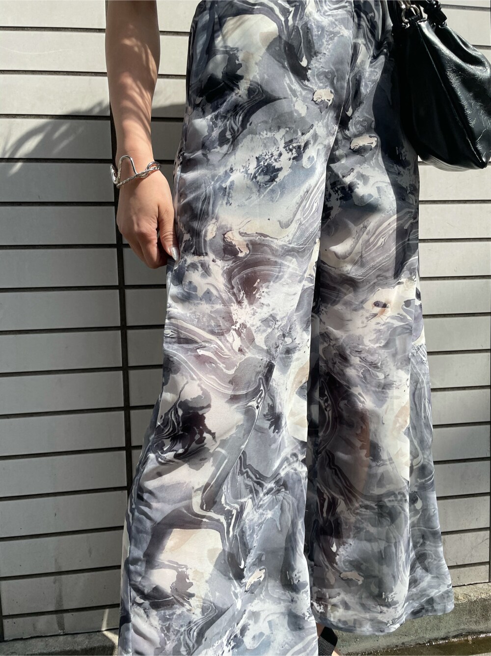 ブラック系のその他パンツ、ブラック系のサンダル、ブラック系のTシャツ/カットソーを着用したレディースの春コーディネートの3枚目の写真