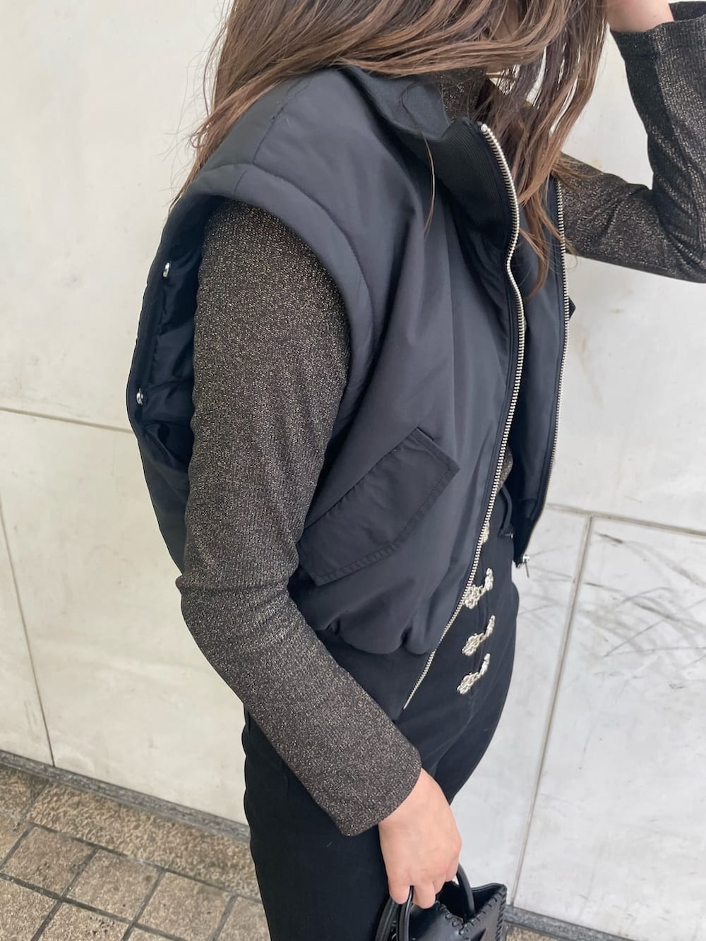 ブラック系のブーツ、ブラック系のデニムパンツ、ブラック系のショルダーバッグを着用したレディースの秋コーディネートの7枚目の写真