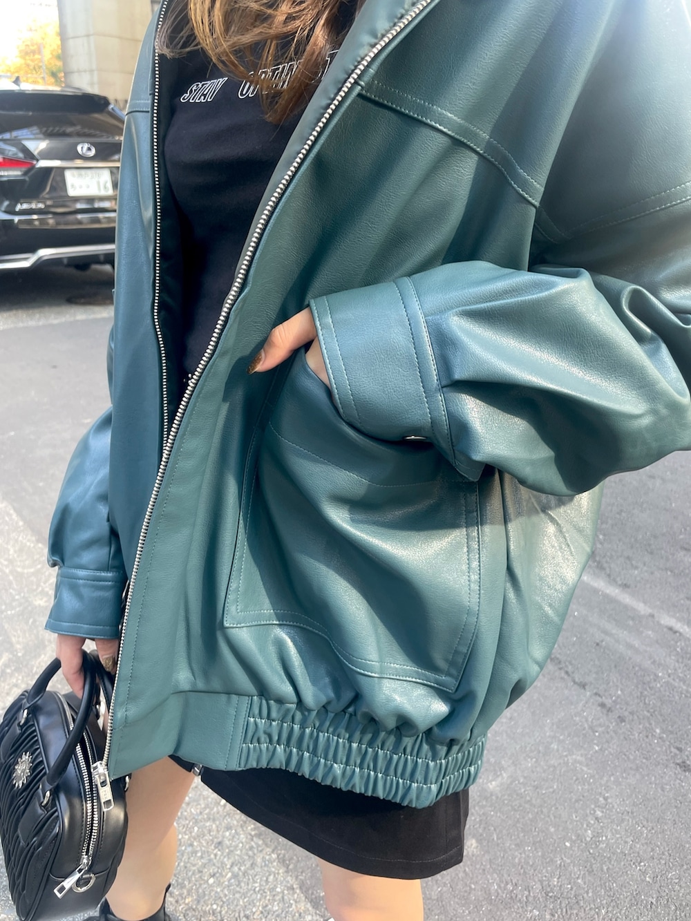 ホワイト系のショルダーバッグ、ブラック系のスカート、ブラック系のTシャツ/カットソーを着用したレディースの秋コーディネートの5枚目の写真