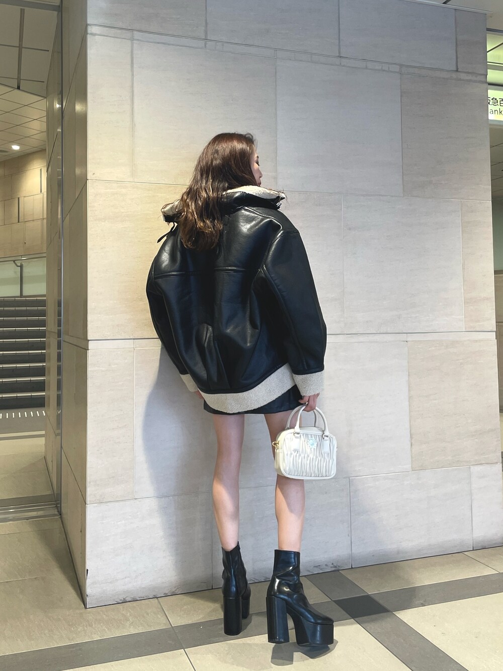 ブラック系のブルゾン、グレー系のTシャツ/カットソー、ブラック系のスカートを着用したレディースの秋コーディネートの2枚目の写真